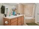 This bathroom features double sinks, wooden cabinets and decorative vase, offering a spacious feel at 5800 Tower Rd # 1201, Denver, CO 80249