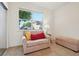 Bedroom featuring a comfortable armchair, an ottoman, and a bright window with neighborhood views at 5800 Tower Rd # 1201, Denver, CO 80249