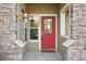 A red door with stone accents and a small porch provides a welcoming entrance at 5800 Tower Rd # 1201, Denver, CO 80249