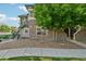 Attractive townhouse exterior with stone accents, mature tree providing shade, and stairs leading to a private entrance at 5800 Tower Rd # 1201, Denver, CO 80249