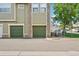 Townhouse complex with green garages and stone accents, creating a pleasant and well-maintained community atmosphere at 5800 Tower Rd # 1201, Denver, CO 80249
