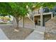 Charming townhouse exterior featuring stone accents, a well-maintained lawn, and a private patio, creating an inviting curb appeal at 5800 Tower Rd # 1201, Denver, CO 80249