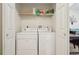 This laundry room has a shelf and a set of white washing machine and dryer at 5800 Tower Rd # 1201, Denver, CO 80249