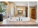 Primary bathroom suite featuring an elegant soaking tub, tile accents and large windows for natural light at 2102 Shoreside Dr, Berthoud, CO 80513