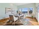 Bright dining room with wood floors, neutral walls, area rug, and large windows at 2102 Shoreside Dr, Berthoud, CO 80513
