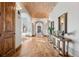 Hallway with brick barrel ceiling, hardwood floors and stylish console tables at 2102 Shoreside Dr, Berthoud, CO 80513