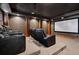 Basement home theater with tiered seating, sconce lighting, and a large screen at 2102 Shoreside Dr, Berthoud, CO 80513