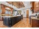 Open concept kitchen with brick ceiling, granite countertops, wood cabinets, and a center island at 2102 Shoreside Dr, Berthoud, CO 80513
