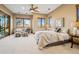 Bright main bedroom featuring a sitting area, hardwood floors, lots of windows and a ceiling fan at 2102 Shoreside Dr, Berthoud, CO 80513