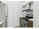 Clean kitchen featuring stainless steel appliances, range hood, and wood finish lower cabinets at 4876 E Kentucky Ave # F, Denver, CO 80246
