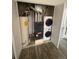 Enclosed utility closet with stacked washer and dryer, water heater and Goodman furnace on laminate floor at 4876 E Kentucky Ave # F, Denver, CO 80246