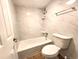 Bright bathroom featuring an alcove tub, a toilet and marble styled walls at 1020 15Th St # 25D, Denver, CO 80202