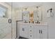 Modern bathroom featuring a dual sink vanity with a walk-in shower and marble tile surround at 2432 Ames St, Edgewater, CO 80214