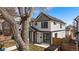 Charming two-story duplex featuring white siding, black trim, green accents, and a well-maintained lawn at 2432 Ames St, Edgewater, CO 80214