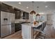 Modern kitchen boasts stainless steel appliances, dark cabinetry, and an island with bar seating at 2432 Ames St, Edgewater, CO 80214
