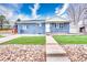 Charming blue brick home with a tidy front yard, and a concrete walkway leading to the front door at 11367 Fowler, Northglenn, CO 80233