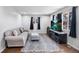 Bright living room with a comfy gray sofa, decorative rug, and a flat-screen television at 11367 Fowler, Northglenn, CO 80233