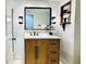 Bathroom with a wood vanity, white countertop, updated fixtures, and a decorative shelf at 10226 E Fair Pl, Englewood, CO 80111