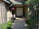 Enchanting front porch featuring double doors, a stylish brick wall, lush greenery, and a peaceful ambiance at 10226 E Fair Pl, Englewood, CO 80111