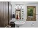 Bathroom featuring a white pedestal sink, a dark wood door, and a window with a view of greenery at 55 Two Moon Rd, Idaho Springs, CO 80452