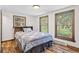 Bedroom with wood floors, two windows with views of the yard, and a bed with a patterned coverlet at 55 Two Moon Rd, Idaho Springs, CO 80452