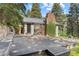 Exterior view of home with rock chimney, ivy, wooden deck, and natural surroundings at 55 Two Moon Rd, Idaho Springs, CO 80452