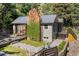 Exterior of the home with stone chimney, wood deck, stone walkway, and lush greenery at 55 Two Moon Rd, Idaho Springs, CO 80452
