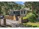 Charming home with a stone wall, wooden deck and stairs, nestled among lush trees at 55 Two Moon Rd, Idaho Springs, CO 80452
