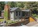 Home featuring a stone chimney, wooden deck and steps, surrounded by greenery at 55 Two Moon Rd, Idaho Springs, CO 80452