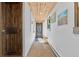 Hallway with wood-paneled ceiling, a rustic door, wood-look flooring, and white walls at 55 Two Moon Rd, Idaho Springs, CO 80452