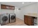 Laundry room featuring a washer, a dryer, cabinets above, and a tiled countertop with storage below at 55 Two Moon Rd, Idaho Springs, CO 80452