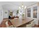 Open concept living and dining area with hardwood floors, large windows, and a modern chandelier at 1245 Garfield St, Denver, CO 80206