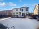 Backyard featuring a patio, lawn covered in snow, and views of surrounding homes under a blue sky at 10020 Strathfield Ln, Highlands Ranch, CO 80126