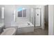 Bright bathroom with tub, tiled floor, and glass shower stall at 10020 Strathfield Ln, Highlands Ranch, CO 80126