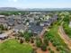 An aerial view displays houses in a neighborhood near green open spaces and distant mountains at 14823 W 70Th Dr # A, Arvada, CO 80007