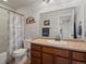 Bathroom featuring granite countertops, wood cabinets, mountain decor, and shower/tub combo at 14823 W 70Th Dr # A, Arvada, CO 80007