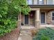 Stone pillars accent the entryway of this inviting front porch with a hanging flower basket at 14823 W 70Th Dr # A, Arvada, CO 80007