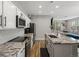 Modern kitchen features white cabinets, granite countertops, stainless steel appliances, and an island with a sink at 14823 W 70Th Dr # A, Arvada, CO 80007