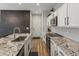 Well-appointed kitchen with stone countertops, white cabinetry, and stainless steel appliances, offering a sleek and efficient design at 14823 W 70Th Dr # A, Arvada, CO 80007