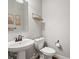 Bright half bathroom with white fixtures, modern mirror, and decorative accents at 14823 W 70Th Dr # A, Arvada, CO 80007