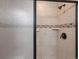 Tiled shower featuring glass door, shower head, and in-wall soap and shampoo holders at 14823 W 70Th Dr # A, Arvada, CO 80007