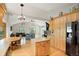 Open-concept kitchen with hardwood floors, an island, wooden cabinets, and stainless steel refrigerator at 41504 Vista Ridge, Parker, CO 80138