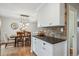 Kitchen area with white cabinets, stone countertops, and a view into the dining area at 6880 E Appleton Cir, Centennial, CO 80112