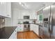 Bright kitchen features white cabinets, stainless steel appliances, hardwood floors, and a garden window over the sink at 6880 E Appleton Cir, Centennial, CO 80112
