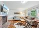 Comfortable living room with a brick fireplace, large TV, hardwood floors, and a view of the outdoors at 6880 E Appleton Cir, Centennial, CO 80112