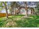Spacious backyard featuring lush green grass, privacy fence, mature trees and patio at 1896 S Marshall Cir, Lakewood, CO 80232