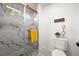 Elegant bathroom features a glass-enclosed shower with marble tiling, gold accents, and a modern toilet at 1896 S Marshall Cir, Lakewood, CO 80232