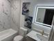 Bathroom with marble tile, modern lighting and bathtub at 1896 S Marshall Cir, Lakewood, CO 80232