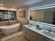 Bright bathroom featuring soaking tub, double vanity, and modern fixtures at 1896 S Marshall Cir, Lakewood, CO 80232