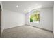 An empty bedroom with a high ceiling, large window and neutral carpeting presents a blank canvas at 1896 S Marshall Cir, Lakewood, CO 80232